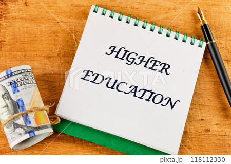 Inscription HIGHER EDUCATION on a blank sheet of notebook against a papyrus background 118112330