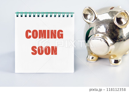 Conceptual coming soon symbol. Copy space. COMING SOON words written on a white notebook, front view on a gray background Conceptual coming soon symbol. Copy space. COMING SOON words written on a white notebook, front view on a gray background 118112358