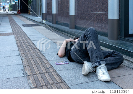 泥酔して歩道で寝込む酔っ払い 118113594
