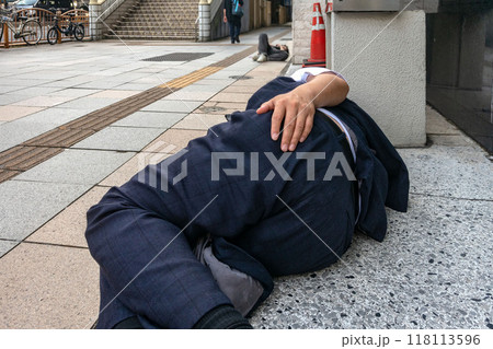 泥酔して歩道で寝込む酔っ払い 泥酔して歩道で寝込む酔っ払い 118113596