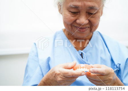 Doctor holding teeth denture in hand for dentist studying about dentistry. 118113754