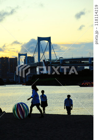 夕暮れのお台場海浜公園の浜辺でビーチボールで遊ぶ高校生のシルエット 118114219