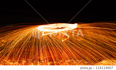 Swing fire Swirl steel wool light photography over the stone with reflex in the water Beautiful light in the sunrise or sunset time, long exposure speed motion style Swing fire Swirl steel wool light photography over the stone with reflex in the water Beautiful light in the sunrise or sunset time, long exposure speed motion style 118114667
