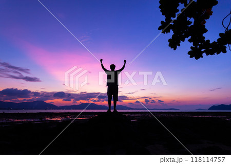Silhouette of man raised his hands with tree frame at sunset or sunrise sky 118114757