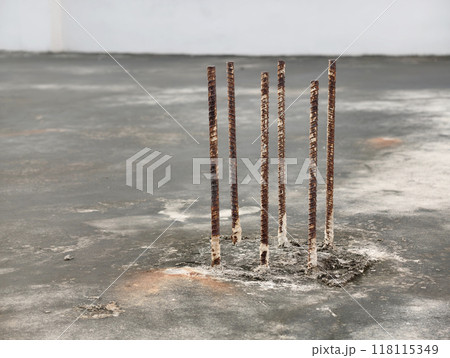 Rusted rebar, part of the building's structural framework, on the rooftop of the building Rusted rebar, part of the building's structural framework, on the rooftop of the building 118115349