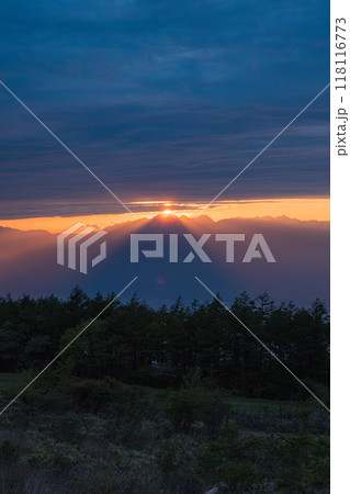 日本　長野県岡谷市と塩尻市の境にある高ボッチ山の高ボッチ高原から見える夕陽の光芒と雲から顔を出した夕 118116773