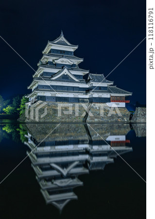 日本　長野県松本市にある国宝、松本城　夜になってライトアップされ内堀の水面に鏡面反射する大天守 118116791