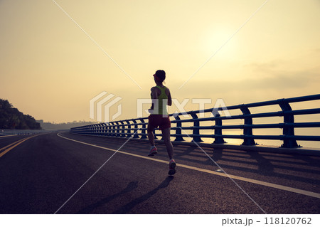 Fitness woman runner running on seaside bridge 118120762