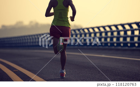 Fitness woman runner running on seaside bridge 118120763
