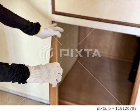 空っぽの押入れの扉を開ける軍手をはめた手元 118120788