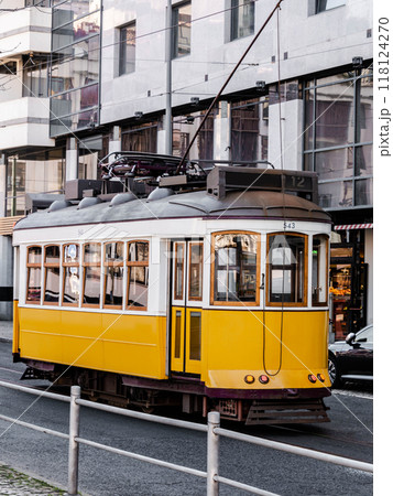 A bright yellow vintage tram moving through the streets of Lisbon A bright yellow vintage tram moving through the streets of Lisbon 118124270