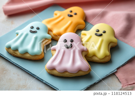 Ghost shaped Halloween cookies decorated with smiling faces 118124513