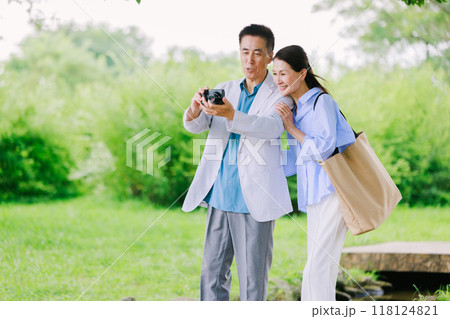 新緑の公園を散策するシニアカップル 新緑の公園を散策するシニアカップル 118124821