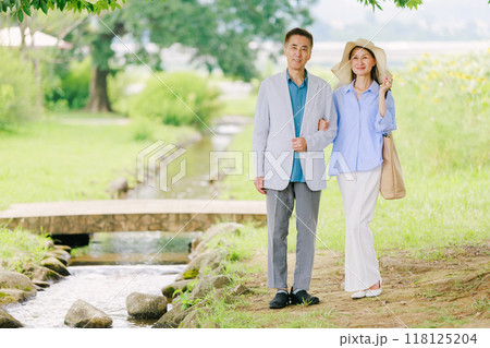 新緑の公園を散策するシニアカップル 118125204