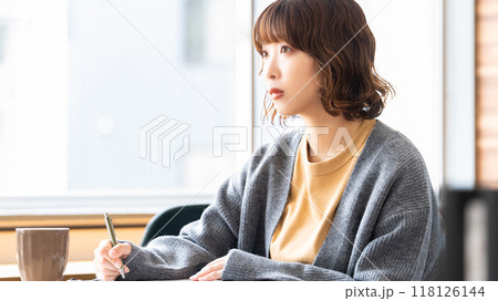 真剣な表情でメモを取る女性 真剣な表情でメモを取る女性 118126144