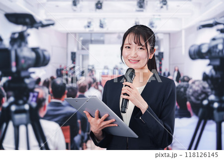 記者会見場からレポートをする女性記者 118126145