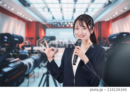 記者会見場からレポートをする女性記者 記者会見場からレポートをする女性記者 118126160