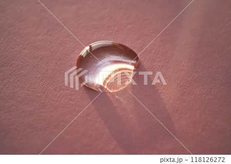 Beautiful volumetric drop of cosmetic product on a pink background. Beautiful volumetric drop of cosmetic product on a pink background. 118126272