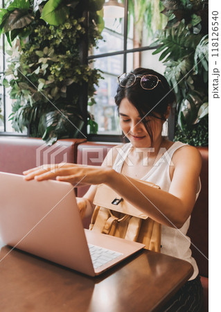 Woman finished her work and turning off the laptop computer. 118126540