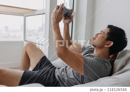 Man concentrate and focus on playing online mobile game in his apartment. 118126588