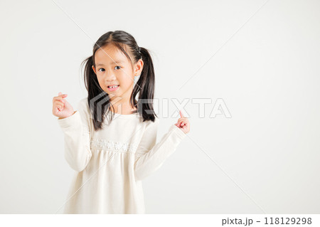 Portrait of happy Asian young kid girl, confidently smiling showing mini heart sign with finger studio shot isolated on white background. Kindergarten child expressing love and joy for Valentine's Day 118129298