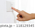 Turn off the light, close up female hand is closing the power switch. Save energy, reduce global warming. 118129345