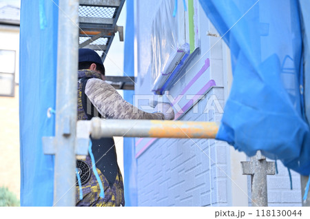 ローラーで塗装する塗装職人　外壁塗装工事　 118130044