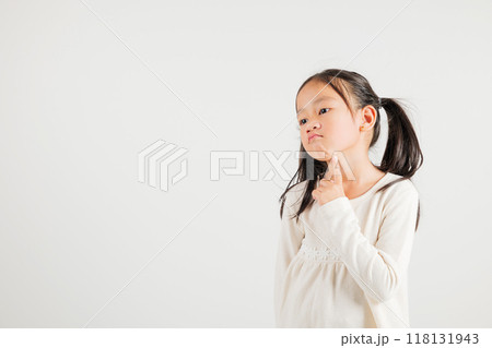 Portrait Asian kid girl deep in thought, standing with chin in hand, pondering a question. Studio shot isolated on white with ample copy space, kindergarten child portraying contemplative expression Portrait Asian kid girl deep in thought, standing with chin in hand, pondering a question. Studio shot isolated on white with ample copy space, kindergarten child portraying contemplative expression 118131943