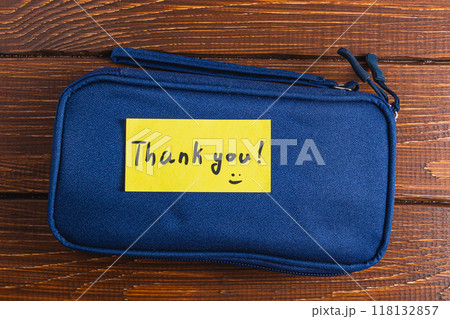 A small blue case with a yellow thank you label 118132857