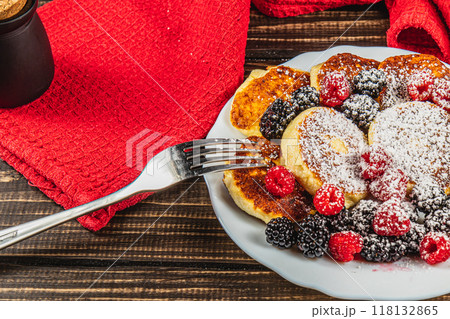 Cottage cheese pancakes with fresh raspberries, blackberries and powdered sugar 118132865