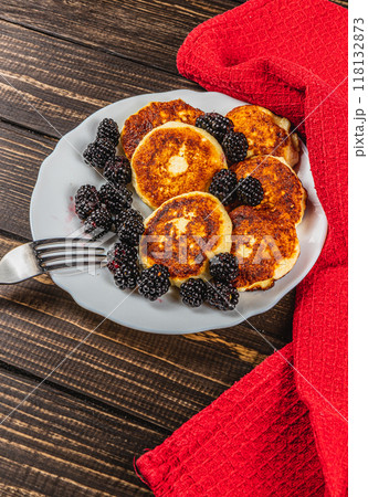 Cottage cheese pancakes with fresh blackberries on a white flat white plate 118132873