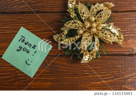 Thank you note on wooden table next to golden flower with bow Thank you note on wooden table next to golden flower with bow 118133001