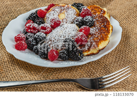 Cottage cheese pancakes with fresh raspberries, blackberries and powdered sugar 118133070