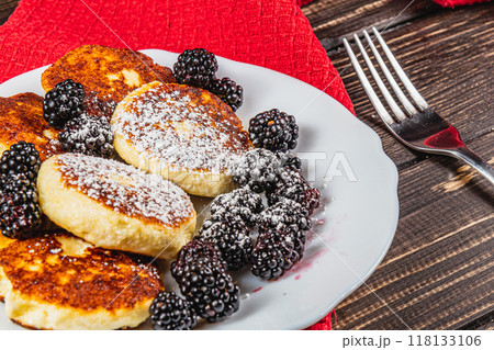 Cottage cheese pancakes with fresh blackberries on a white flat white plate 118133106