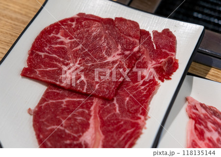 Korean Style Barbecue on plate in front of stainless grill. BBQ rare meat with soft focus Korean Style Barbecue on plate in front of stainless grill. BBQ rare meat with soft focus 118135144