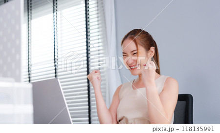 Successful Asian Businesswoman Triumphing with Laptop in Modern Office 118135991