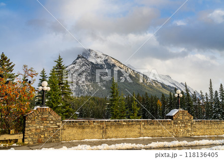 Snow-covered Mount Rundle mountain range with snowy forest over blue sky and white clouds in winter sunny day. Banff National Park, Canadian Rockies. Snow-covered Mount Rundle mountain range with snowy forest over blue sky and white clouds in winter sunny day. Banff National Park, Canadian Rockies. 118136405