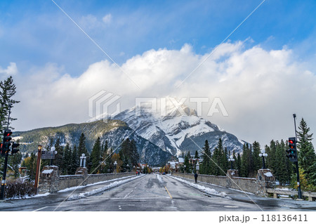 Banff Avenue in snowy autumn sunny day. Snow-covered Cascade Mountain with blue sky and white clouds in the background. Banff National Park, Canadian Rockies. Banff, Canada 118136411