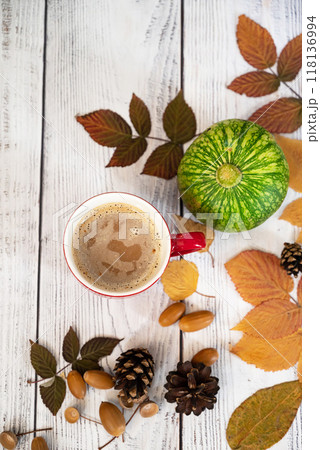 Autumn, fall leaves, hot steaming cup of coffee and a warm scarf on wooden table background. Seasonal, morning coffee, Sunday relaxing and still life concept. 118136994