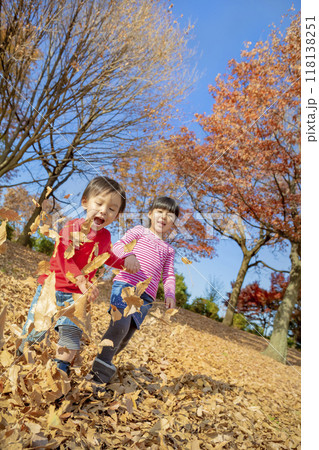 紅葉の公園で遊ぶ姉と弟 118138251