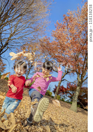 紅葉の公園で遊ぶ姉と弟 118138258