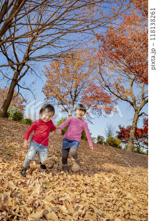 紅葉の公園で遊ぶ姉と弟 118138261