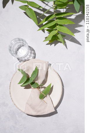 Festive table setting with plate and glass for a celebration with eucalyptus branches  118142158