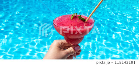 Chilled raspberry or strawberry Daiquiri with mint in hand by pool on sunny day. Concept of summer fun and refreshing drinks Chilled raspberry or strawberry Daiquiri with mint in hand by pool on sunny day. Concept of summer fun and refreshing drinks 118142191