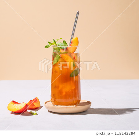 Refreshing peach ice and mint tea. Vegan homemade cold summer drink on tall glass Refreshing peach ice and mint tea. Vegan homemade cold summer drink on tall glass 118142294