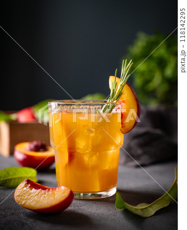 Peach tea with ice and rosemary on a glass. Vegan homemade healthy  drink on a dark background 118142295