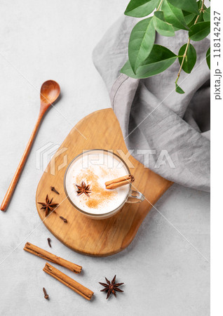Traditional Indian masala chai latte in a glass cup. Hot drink with milk, spices Traditional Indian masala chai latte in a glass cup. Hot drink with milk, spices 118142427