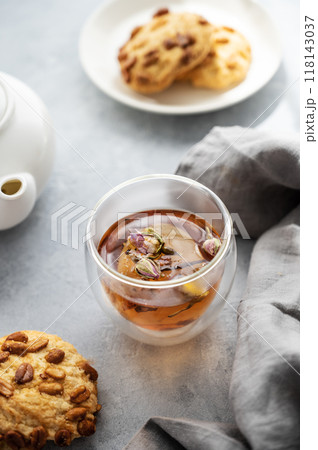 A cup of herbal tea, teapot and homemade cookies on a blue background  close up.  118143037