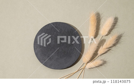 Round empty slate board on a green background with golden branches. Round empty slate board on a green background with golden branches. 118143075