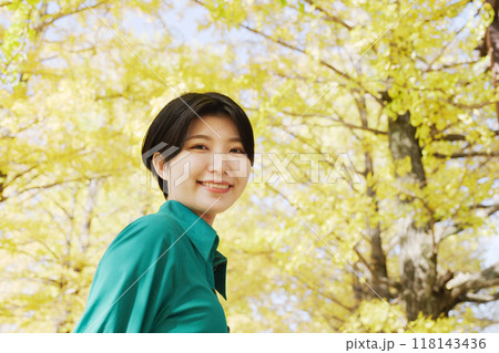 イチョウ並木の紅葉を楽しむ若い女性 イチョウ並木の紅葉を楽しむ若い女性 118143436